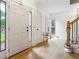 Inviting foyer with hardwood floors, a staircase, and natural light streaming through the window at 9545 Kingston Crossing Cir, Alpharetta, GA 30022