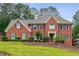 Beautiful two-story brick home with a manicured lawn and mature trees, giving it a welcoming curb appeal at 9545 Kingston Crossing Cir, Alpharetta, GA 30022