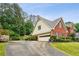 Side view of a brick home with a two-car garage and well-kept landscaping at 9545 Kingston Crossing Cir, Alpharetta, GA 30022