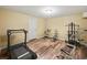 Finished basement with wood floors and a workout area with a treadmill and weight machines at 11950 Wildwood Springs Dr, Roswell, GA 30075