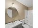 Cozy bathroom features a modern round mirror, updated vanity, and shower-tub combination at 11950 Wildwood Springs Dr, Roswell, GA 30075