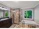 Bathroom featuring decorative wall tiles, a glass shower, and a large soaking tub at 11950 Wildwood Springs Dr, Roswell, GA 30075