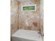Bathroom showcasing decorative wall tiles and a bath tub with a small window at 11950 Wildwood Springs Dr, Roswell, GA 30075