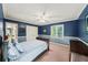 Bedroom with blue walls, carpet flooring, white trim, ceiling fan and natural light from the window at 11950 Wildwood Springs Dr, Roswell, GA 30075