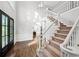 Grand foyer with hardwood floors, high ceilings, and a staircase with white railings at 11950 Wildwood Springs Dr, Roswell, GA 30075