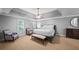 Spacious main bedroom featuring a trey ceiling, ceiling fan, two sitting chairs and a dresser at 11950 Wildwood Springs Dr, Roswell, GA 30075