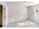 Neutral-toned bedroom with a window and closet offers ample space and natural light, creating a serene retreat at 4954 River Overlook Way, Lithonia, GA 30038