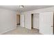 Carpeted bedroom features an open closet with ample space and a door to the next room at 4954 River Overlook Way, Lithonia, GA 30038