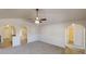 Open-concept living room with arched doorways, and neutral walls and carpet offers a bright and inviting living space at 4954 River Overlook Way, Lithonia, GA 30038