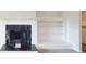 Cozy living room featuring a white fireplace, shelving, and neutral-colored walls with natural light at 4954 River Overlook Way, Lithonia, GA 30038