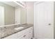 Elegant bathroom featuring a granite countertop vanity, a large mirror, and white cabinets at 5229 Kirk Dr, Atlanta, GA 30349