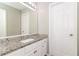 Well-lit bathroom with a granite countertop, white cabinets, and a large mirror at 5229 Kirk Dr, Atlanta, GA 30349