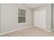 Bedroom with neutral carpet and walls, a window with blinds and a double door closet at 5229 Kirk Dr, Atlanta, GA 30349