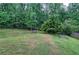 Backyard with mature trees, a fire pit, and a swing at 70 Ashbury Ct, Dallas, GA 30157