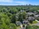 An aerial view captures neighborhood homes nestled amongst mature trees with a city skyline in the distance at 1175 Haven Brook Ne Way, Brookhaven, GA 30319