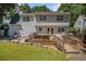 View of a home's backyard featuring a wooden deck with multiple seating areas and lush green lawn at 1175 Haven Brook Ne Way, Brookhaven, GA 30319