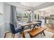 Bright dining area featuring a rustic wood table, modern lighting, and views of the backyard at 1175 Haven Brook Ne Way, Brookhaven, GA 30319