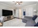 Comfortable living room with a large TV, a modern couch, and hardwood floors at 1175 Haven Brook Ne Way, Brookhaven, GA 30319
