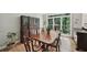 Bright dining room showcasing a wooden table, chairs, a china cabinet, and large windows with green views at 1243 Williamswood Pointe, Decatur, GA 30033