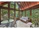 Cozy sunroom surrounded by trees, with tiled floors, a table, and a comfortable seating area at 1243 Williamswood Pointe, Decatur, GA 30033