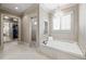 Elegant bathroom showcasing a jacuzzi tub, shuttered windows, and passage to the walk-in closet and shower at 341 Carl Sanders Dr, Acworth, GA 30101