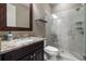Modern bathroom featuring a marble countertop, dark wood vanity, and tiled shower with glass door at 341 Carl Sanders Dr, Acworth, GA 30101