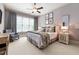 Cozy bedroom featuring neutral tones, a comfortable rocking chair, and soft natural light from a large window at 341 Carl Sanders Dr, Acworth, GA 30101