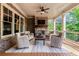 Relaxing covered porch with a stone fireplace, ceiling fan, and comfortable seating for outdoor living at 341 Carl Sanders Dr, Acworth, GA 30101