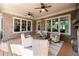 Inviting covered porch featuring a brick accent wall, ceiling fans, and cozy seating for relaxation at 341 Carl Sanders Dr, Acworth, GA 30101