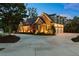 Beautiful shot of home's exterior at dusk, showing 3-car garage and well-lit driveway at 341 Carl Sanders Dr, Acworth, GA 30101