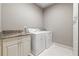 Functional laundry room with granite counters, ample storage, and modern washer and dryer at 341 Carl Sanders Dr, Acworth, GA 30101