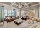Comfortable living room with a view into the kitchen, a leather sofa, a patterned easy chair, and coffered ceiling at 341 Carl Sanders Dr, Acworth, GA 30101