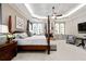 Spacious main bedroom showcasing tray ceiling, built-in bookshelves and fireplace, a sitting area, and four-poster bed at 341 Carl Sanders Dr, Acworth, GA 30101