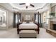 Large main bedroom featuring a tray ceiling, fireplace, seating area, and luxurious four poster bed at 341 Carl Sanders Dr, Acworth, GA 30101