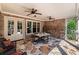 Covered stone patio with ceiling fans, dining set, stone fireplace and brick wall at 341 Carl Sanders Dr, Acworth, GA 30101