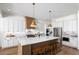 Bright kitchen featuring a large center island with seating, stainless steel appliances, and white cabinets at 7460 Trotting Trl, Cumming, GA 30040