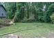A view of the backyard showcasing a spacious lawn surrounded by lush trees at 1341 Timbercrest Ct, Lawrenceville, GA 30045