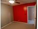 Bedroom with neutral carpet and contrasting red accent wall and doorway view to other rooms at 1341 Timbercrest Ct, Lawrenceville, GA 30045