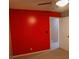 Bedroom with neutral carpet, door, and contrasting red accent wall at 1341 Timbercrest Ct, Lawrenceville, GA 30045