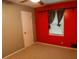Bedroom features neutral carpet, window, ceiling fan, and contrasting red accent wall at 1341 Timbercrest Ct, Lawrenceville, GA 30045