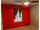 Bedroom features neutral carpet, window, ceiling fan, and contrasting red accent wall at 1341 Timbercrest Ct, Lawrenceville, GA 30045