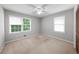 Bright bedroom featuring carpet, neutral paint, and two windows with views of the outdoors at 1541 Eldonlas Ct, Stone Mountain, GA 30087