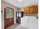 Bright laundry room with washer, dryer, storage, and a view of the fenced backyard at 1541 Eldonlas Ct, Stone Mountain, GA 30087