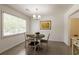 Bright dining area features a modern chandelier, a round wood table, and a window providing ample natural light at 340 Monivea Ln, Roswell, GA 30075
