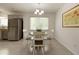 Bright dining area features a modern chandelier, a round wood table, and a window providing ample natural light at 340 Monivea Ln, Roswell, GA 30075