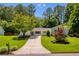 Charming single-story home with well-manicured lawn, mature trees, and inviting driveway, all under a bright blue sky at 340 Monivea Ln, Roswell, GA 30075