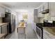 Spacious kitchen showcasing stainless steel appliances, grey cabinets, and a view to the dining area at 340 Monivea Ln, Roswell, GA 30075