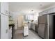 Well-lit kitchen featuring stainless steel appliances, stylish grey cabinetry, and a central island for added workspace at 340 Monivea Ln, Roswell, GA 30075