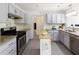 Bright kitchen featuring stainless steel appliances, stylish grey cabinetry, and a central island for added workspace at 340 Monivea Ln, Roswell, GA 30075