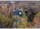 An aerial view of a single-story house with an asphalt driveway, nestled among trees, offering privacy at 7427 Hollis Rd, Douglasville, GA 30135